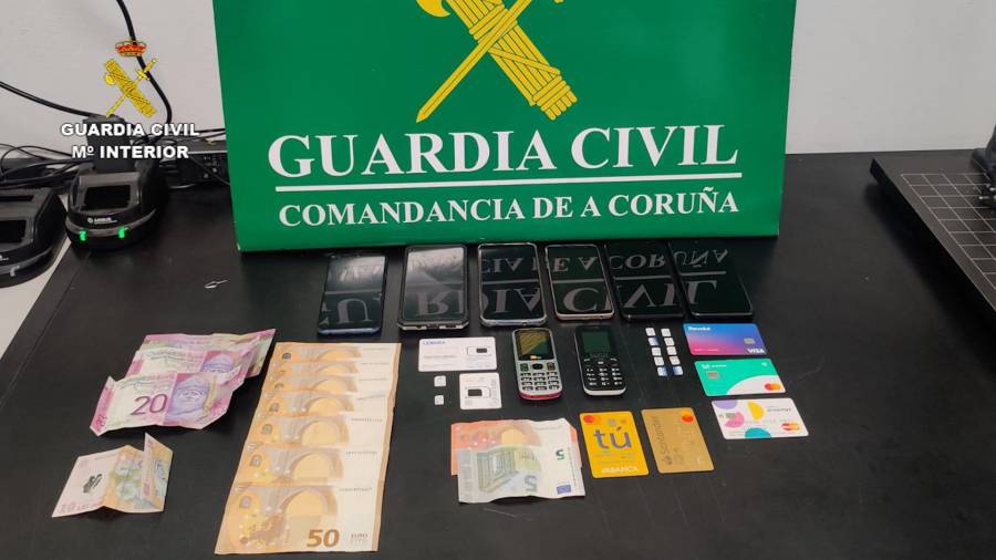 Teléfonos, tarjetas y dinero en efectivo incautado al grupo criminal desactivado en Carballo. Foto: Guardia Civil