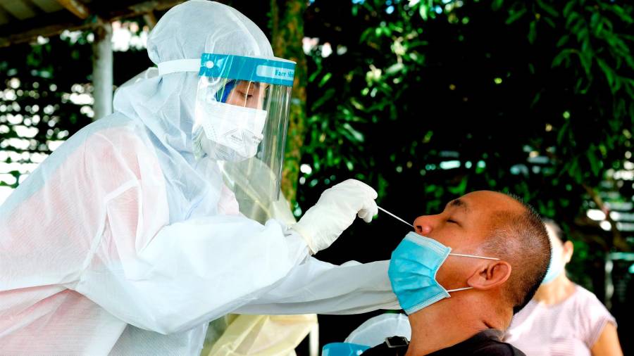 Una trabajadora sanitaria toma una muestra a un hombre para un test de coronavirus en la ciudad malasia de Sandakan. FOTO: Arjasneh Ahmad
