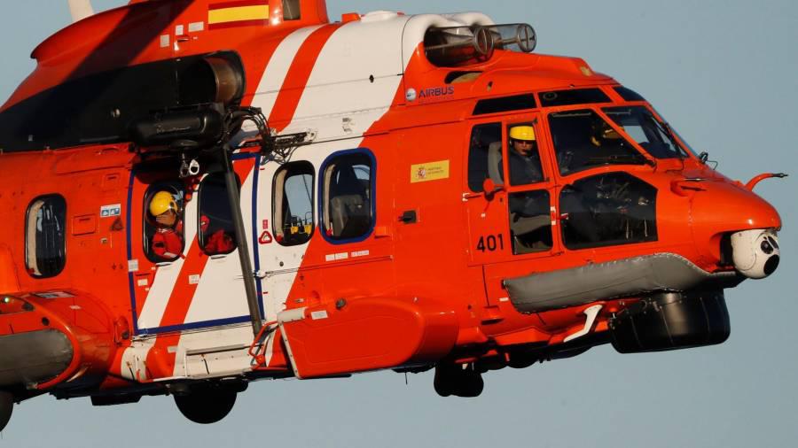 Imagen del helicóptero Helimer 401, ayer, durante la búsqueda de los dos jóvenes desaparecidos tras volcar su kayak en Porto do Son. EFE