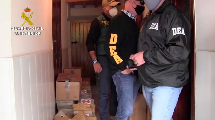 COLABORACIÓN. Dos agentes de la DEA y uno de la Guardia Civil en el chalé de Ribadeo con los paquetes de cocaína en las cajas