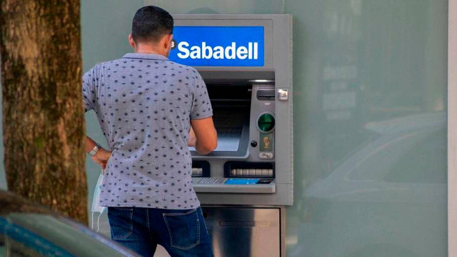Un joven sacando dinero en el cajero de una sucursal del banco Sabadell en Santiago de Compostela. Foto: Angy A. E.