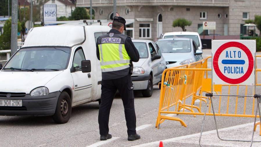 Miembros de la policía vigilan el paso en la frontera con Portugal en la localidad de Salvaterra do Miño, en Pontevedra, el pasado 15 de junio para facilitar el tránsito de los trabajadores entre las ciudades de ambos lados del río Miño. EFE/ Salvador Sas