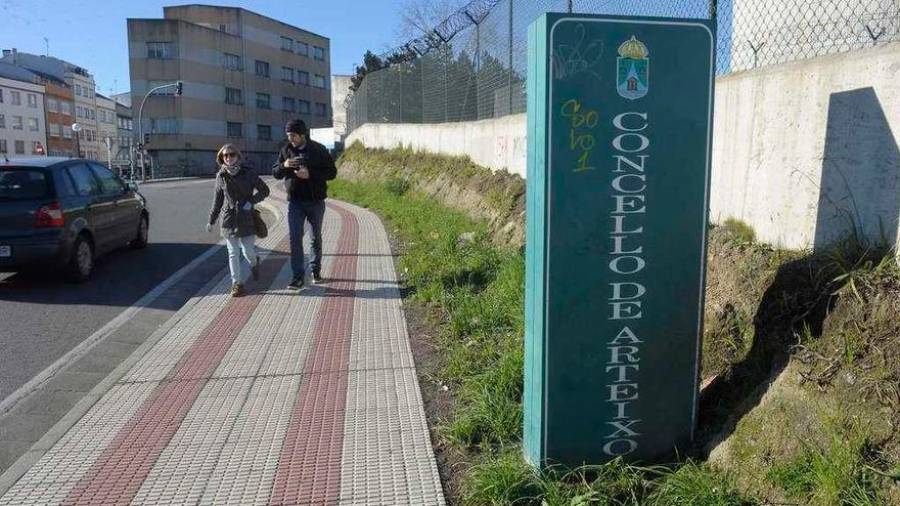 Arteixo. Dos personas caminan por la acera de salida del municipio coruñés mejor valorado por la población gallega. Foto: Europa Press