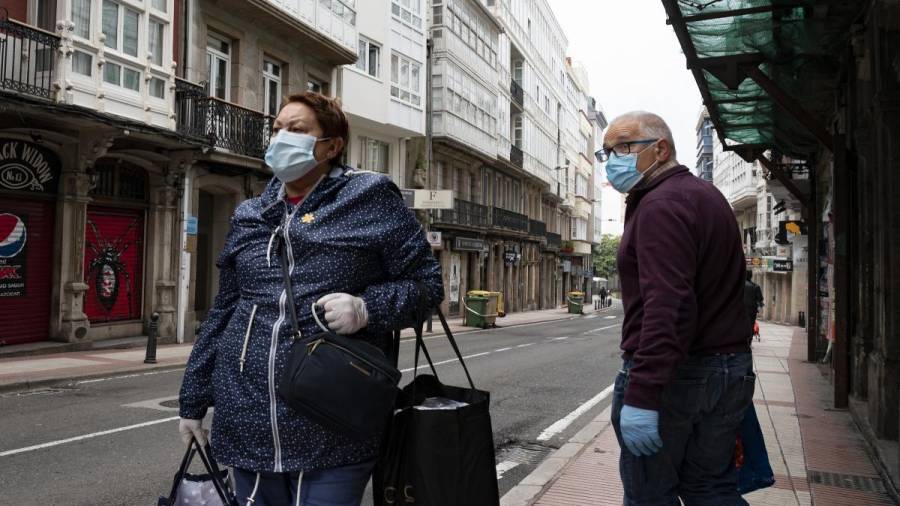 En la foto de archivo, dos personas con mascarilla en una calle de A Coruña. EUROPA PRESS