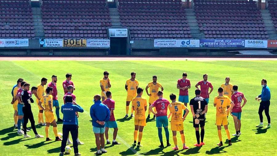 CÓNCLAVE Yago Iglesias (d), dando instrucciones a sus futbolistas, reunidos sobre el césped antes de comenzar el partido, ayer. Foto: Brais Fernández