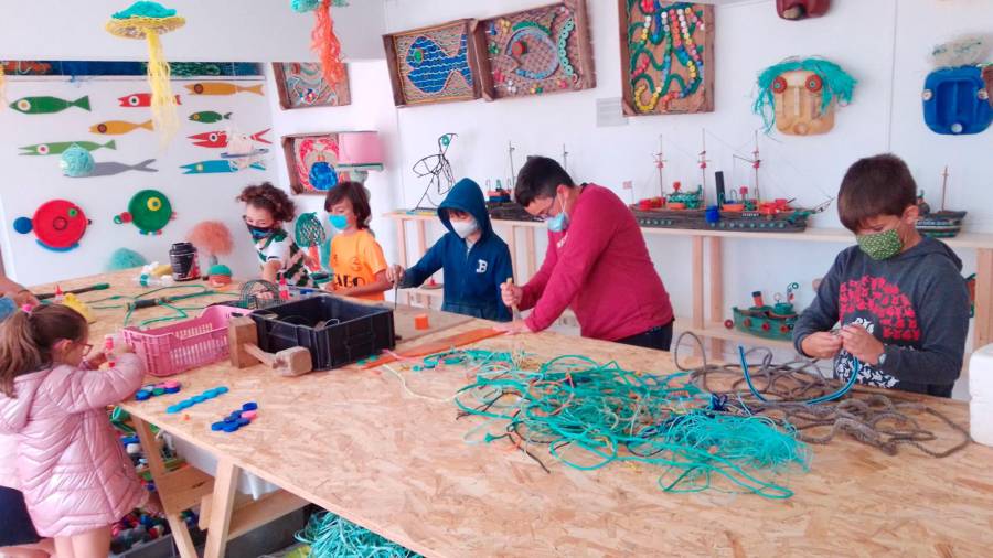 Nenos e nenas de Camelle elaborando pezas artísticas co refugallo do mar recollido por Mar de Fábula. Foto: Mar de Fábula