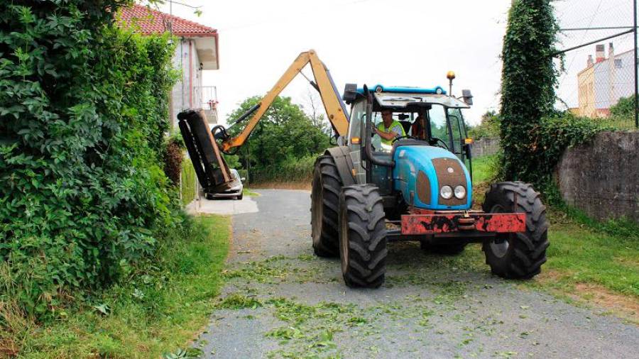 Un tractor adecentando márgenes viarios en la localidad carballesa de A Brea. Foto: Lema