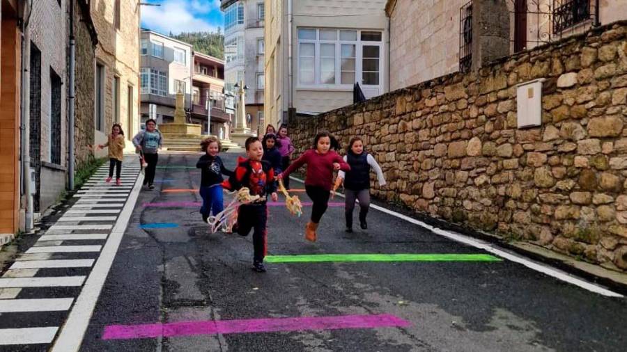 Nenos e nenas correndo pola coloreada rúa do Candil de Vimianzo. Foto: Sandra González