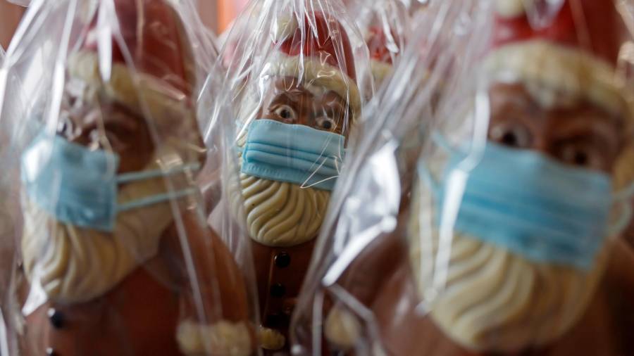 Figuras de chocolate de Papa Noel con mascarilla en las instalaciones de la compañía chocolatera Wawi en Pirmasens, Alemania, el 27 de noviembre de 2020. EFE/RONALD WITTEK