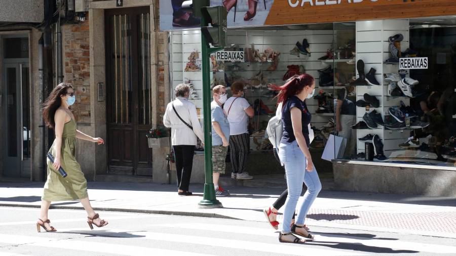 Consumidores pasando por delante de un comercio de proximidad en la capital gallega. Foto: ECG 