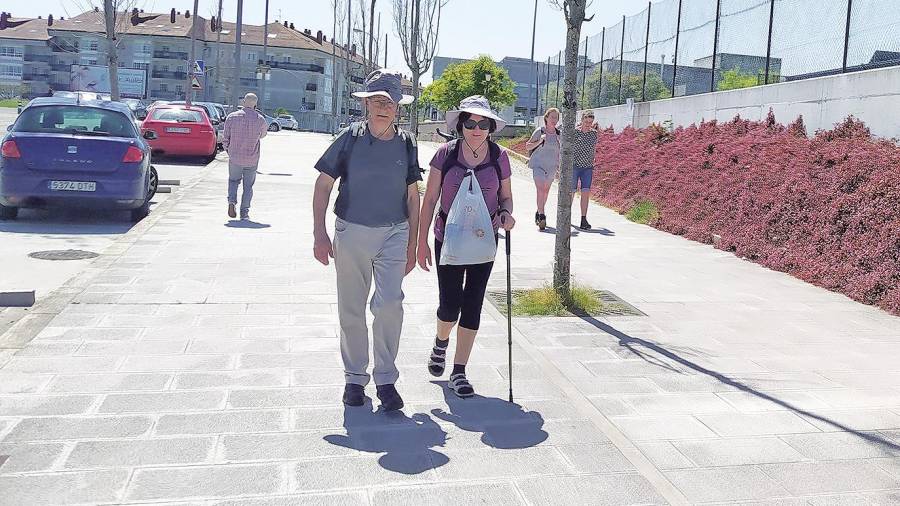 Peregrinos y viandantes por la Travesía do Porto do Milladoiro, donde se ubicará uno de los nuevos ‘pasominutos’. Foto: CG