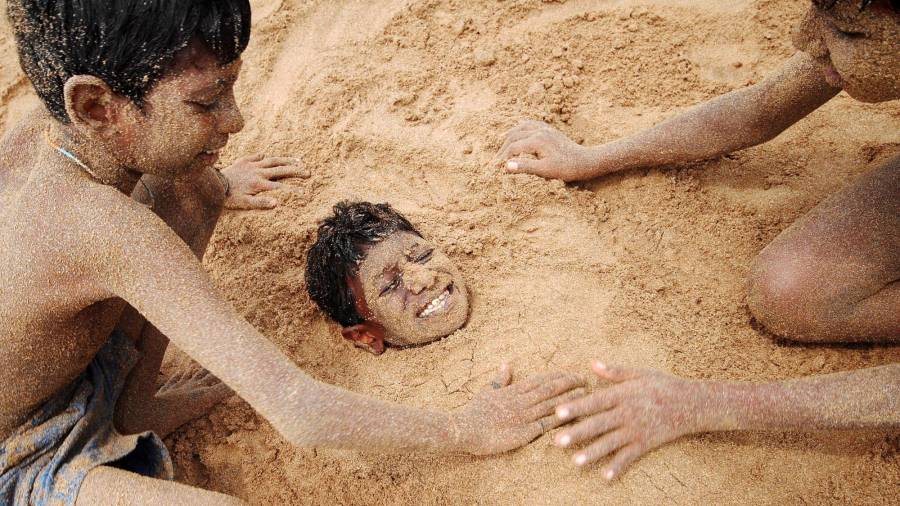 Niños indios jugando en la arena de la playa de Juhu en Mumbai. (Autor, Divyakant Solanki. Fuente, EFE)