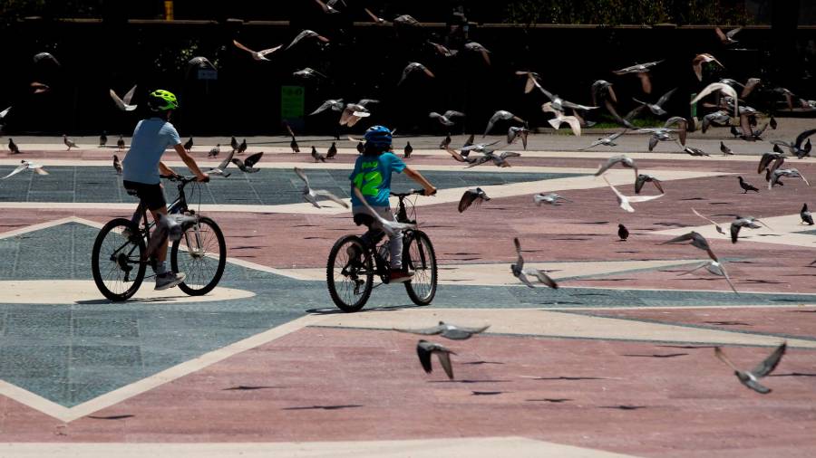 BARCELONA, 28/04/2020.- Dos niños pasean en bicicleta por la Plaza de Cataluña de Barcelona este martes, cuando se cumplen 45 días de confinamiento por el estado de alarma decretado por el Gobierno por la crisis del coronavirus. EFE/Enric Fontcuberta