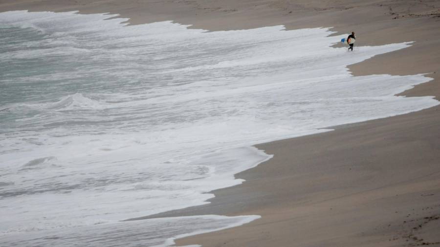 A CORUÑA, 27/10/2020.- Un surfista sale del agua en la playa del Orzán, en A Coruña, donde de cara a la jornada de mañana se espera la llegada de un fuerte temporal de mar, que ha obligado a decretar la alerta roja (riesgo extremo) en el litoral de A Coruña con olas de más de ocho metros. EFE/ Cabalar