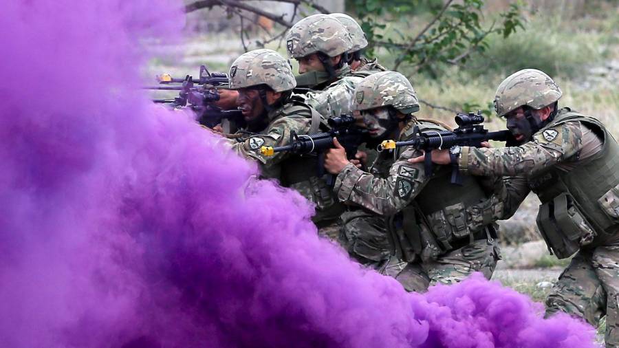 Soldados moviéndose a través del humo malva en unos ejercicios militares en la base de Vaziani en Georgia. (Autor, Zurab Kurtsikidze. Fuente, EFE)