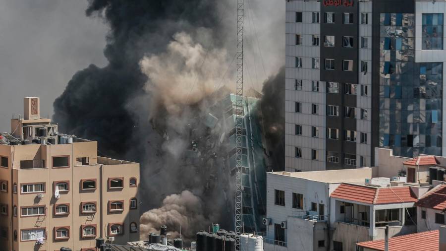 Territorios palestinos, Ciudad de Gaza: Al-Jalaa torre, que alberga apartamentos y varios medios de comunicación outlets, incluyendo La Associated Press y Al Jazeera, se derrumba después de ser alcanzado por ataques aéreos israelíes, entre el escalating llamarada de israelí-violencia palestina. Foto: Mohammed Talatene/dpa 15/05/2021