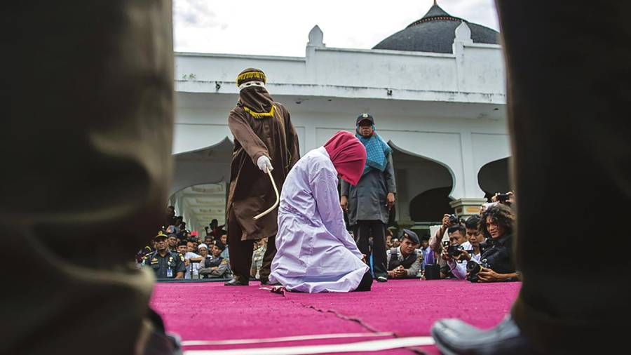 Una mujer recibe latigazos con una caña como castigo en Banda Aceh, Indonesia, por mantener relaciones sexuales fuera del matrimonio.