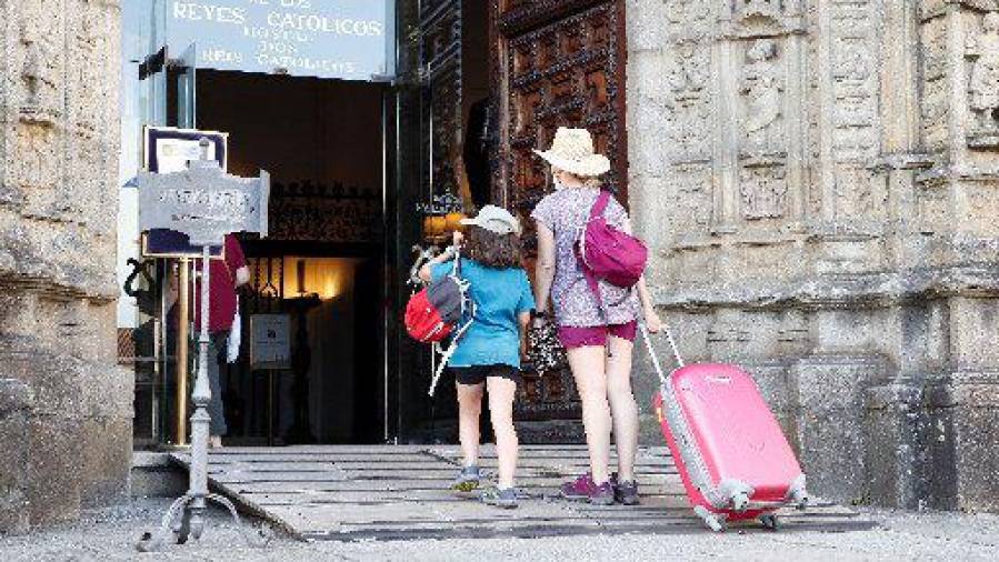 Turistas en el casco histórico de Santiago de Compostela tras la pandemia, entrando en el Hostal dos Reis Católicos. ECG/Antonio Hernández