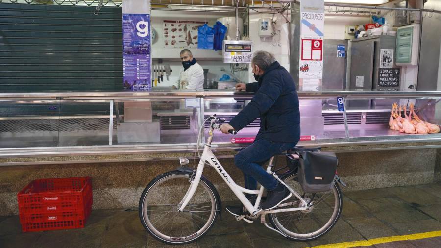 anormalidad. Uno de los pocos clientes que pasó ayer por la Praza de Abastos de Santiago haciendo la compra en bicicleta. Foto: Lavandeira Jr 