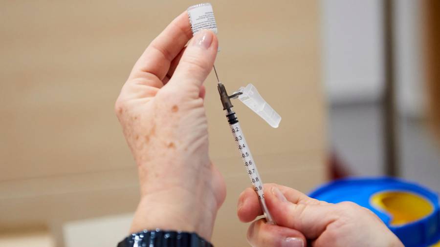 Una trabajadora sanitaria sostiene una jeringuilla con la segunda dosis de la vacuna de Pfizer-BioNTech antes de inocularla. Foto: E. Press