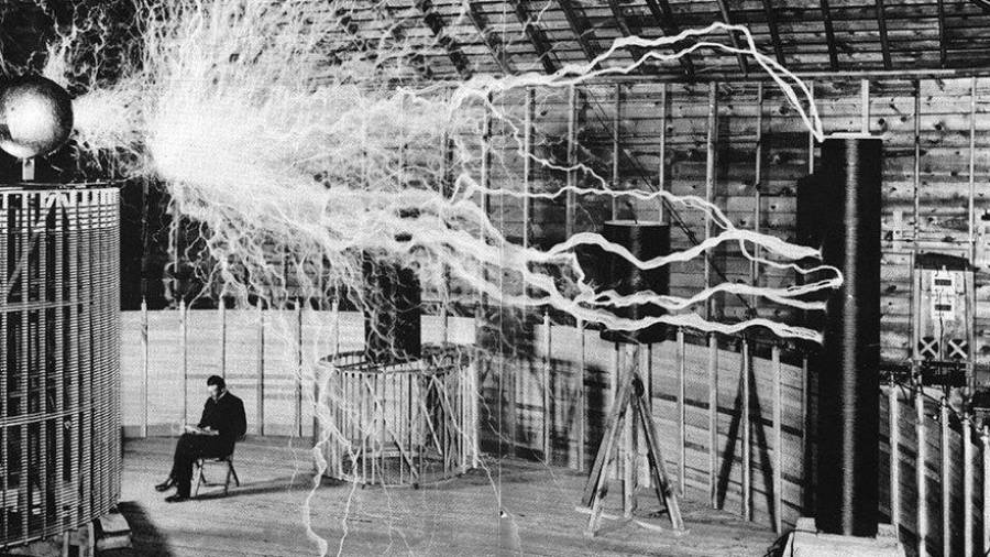 Nikola Tesla sentado en su laboratorio con su Magnifying Transmitter. (Fuente, www.culturainquieta.com)