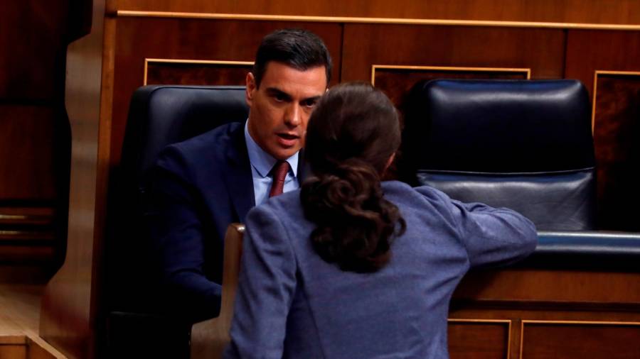 Pedro Sánchez charla desde su escaño en el Congreso con Pablo Iglesias. Foto: J.J. Guillén/Efe