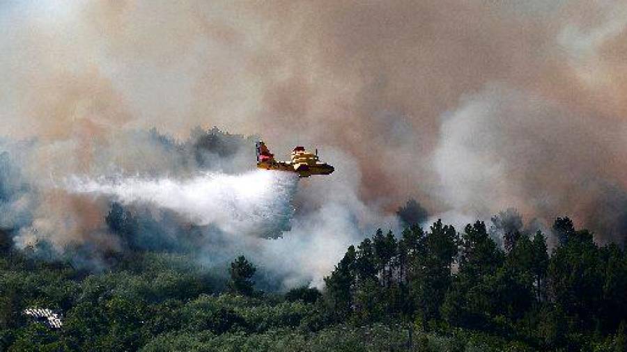 Equipos terrestres y aéreos trabajan en la extinción de un incendio ubicado en Ourense. FOTO: EFE