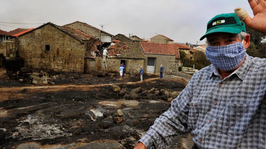 Vecinos de la parroquia de Montes comprueban el estado de sus viviendas tras el paso del fuego, en Cualedro, Ourense. FOTO: Rosa Veiga - Europa Press