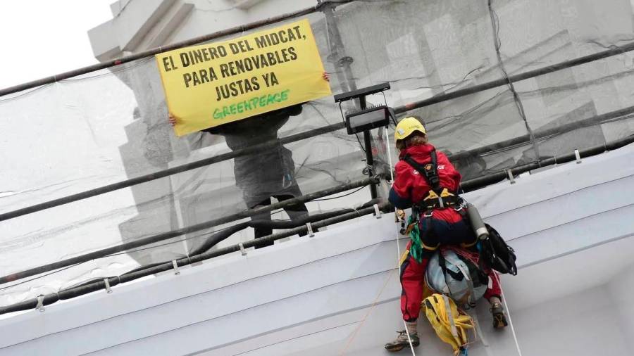 Activistas de Greenpeace colocan una gran pancarta en la fachada de un edificio próximo al lugar donde se celebra la cumbre bilateral entre España y Alemania en A Coruña, este miércoles. Foto: Lavandeira/Efe