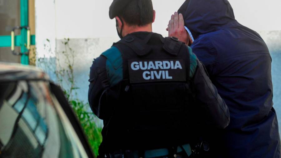 Un guardacivil acompaña a un detenido en una operación antidroga llevada a cabo recientemente en Galicia Foto: Sxenick
