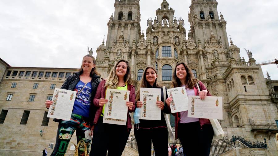 Grupo de cuatro peregrinas que muestran orgullosas su Compostela, recogida ayer. Foto: Fernando Blanco