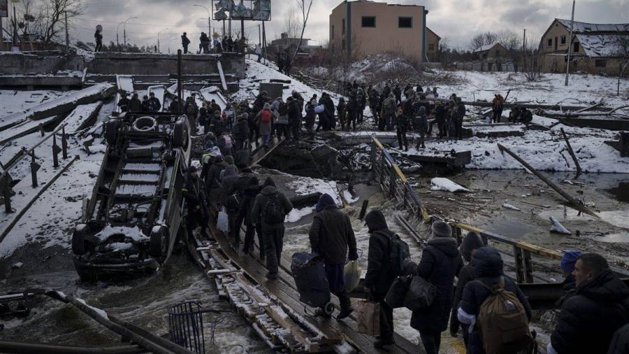 Un grupo de ucranianos cruzan un camino improvisado tras los bombardeos rusos a la ciudad de Irpin. (Fuente, www.nationalgeographic.com.es/fotografia)