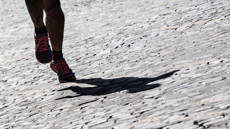 Un participante de la maratón de Roma cruza el empedrado gris de la ciudad. (Autor, Angelo Carconi. Fuente, EFE)