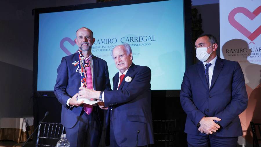 Ramiro Carregal entrega o premio a Carlos peña Gil en presenza do conselleiro de Sanidade, García Comesaña