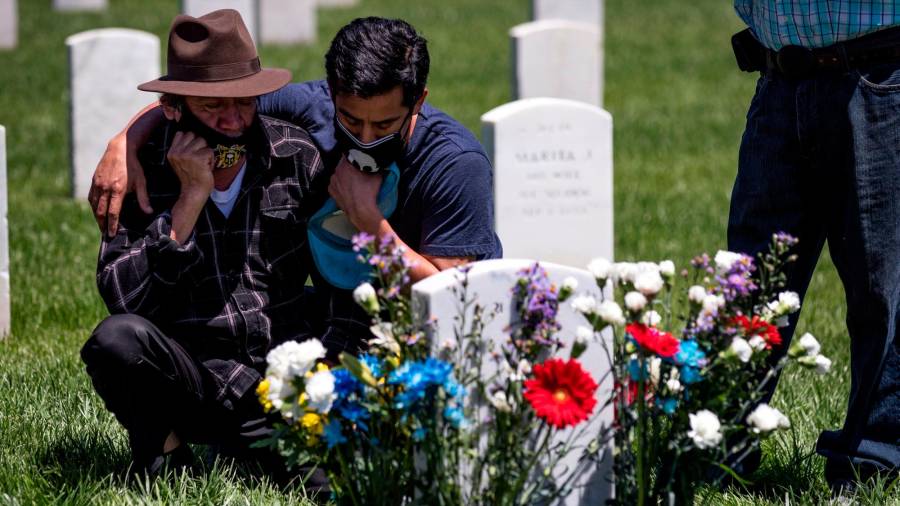 LOS ÁNGELES (EE.UU.). Salomon, a la izquierda, y César visitan con mascarillas la tumba de su hijo y hermano en el Día de los Caídos en el Cementerio Nacional de Los Ángeles en medio de la pandemia del coronavirus.