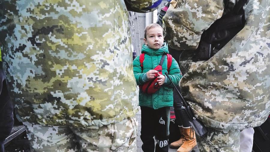Un niño mira a los soldados mientras estos revisan pasaportes antes de coger el tren a Polonia (Lviv). Foto: B. Smith