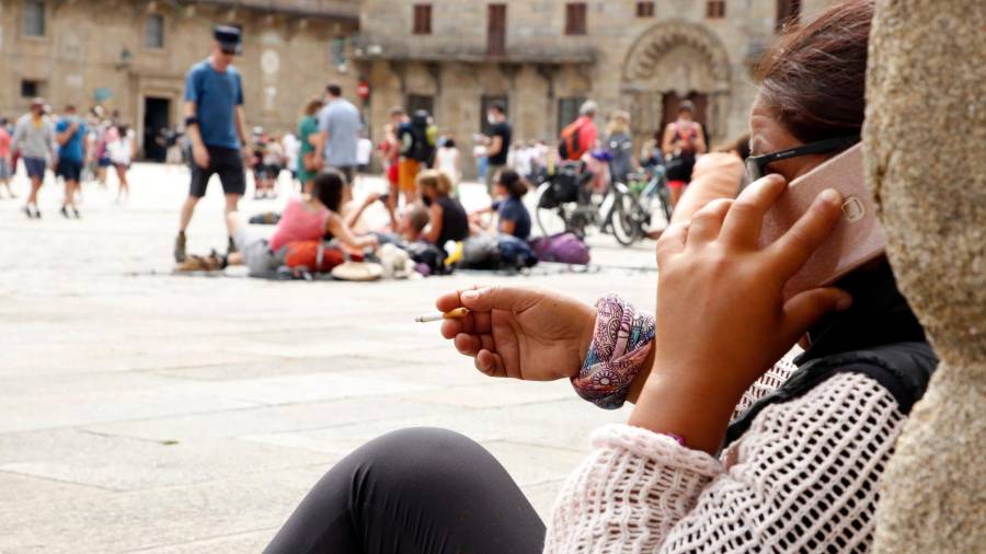 Una peregrina fumando en la plaza del Obradoiro hace unos meses. Foto: Antonio Hernández