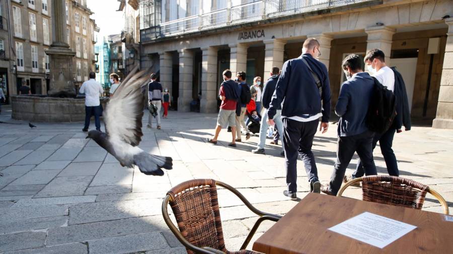 Una paloma levanta el vuelo desde la mesa de la terraza de un bar de la céntrica praza de Cervantes. Foto: Antonio Hernández