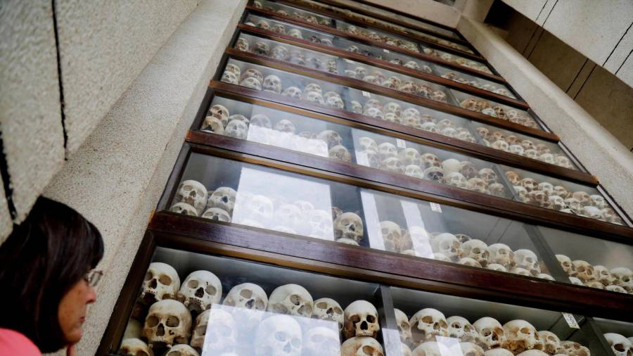 2018. Una turista observa las calaveras de muchas de las víctimas fallecidas bajo el régimen de los Jemeres Rojos. Esta exposición de encuentra en el Centro del Genocidio Choeung Ek de Camboya. (Autor, Mak Remissa. Fuente, EFE)