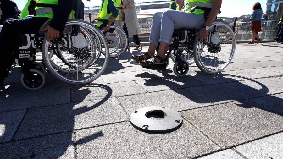 Persoas en silla de rodas comproban as dificultades dos dependentes. Foto: Antonio Hernández