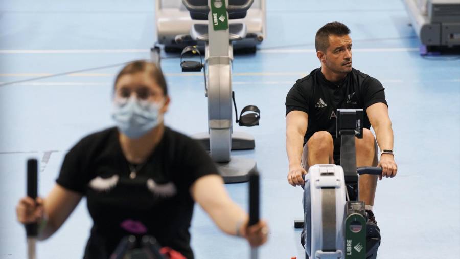 Dos personas, una de ellas proteginas con mascarilla, realizan ejercicio en un gimnasio de Santiago FOTO: Álvaro Ballesteros