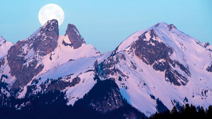Vista de la Superluna tras las montañas Les Jumelles. Foto sacada desde la localidad de Plambuit, Suiza. (Autor, Anthony Anex para EFE).