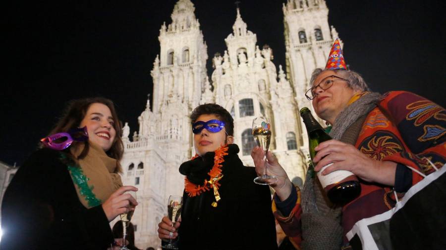Tres personas celebrando el día de Nochevieja, el pasado año, en la Plaza del Obradoiro. Foto: Antonio Hernández 