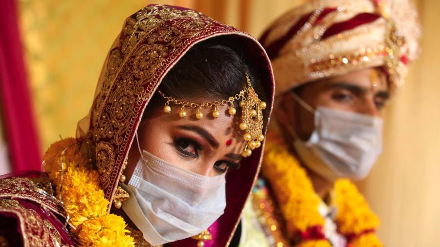 Bride Angoori y su novio Ashish con máscaras durante su boda en Bhopal. (Autor, Sanjeev Gupta. Fuente, EFE)