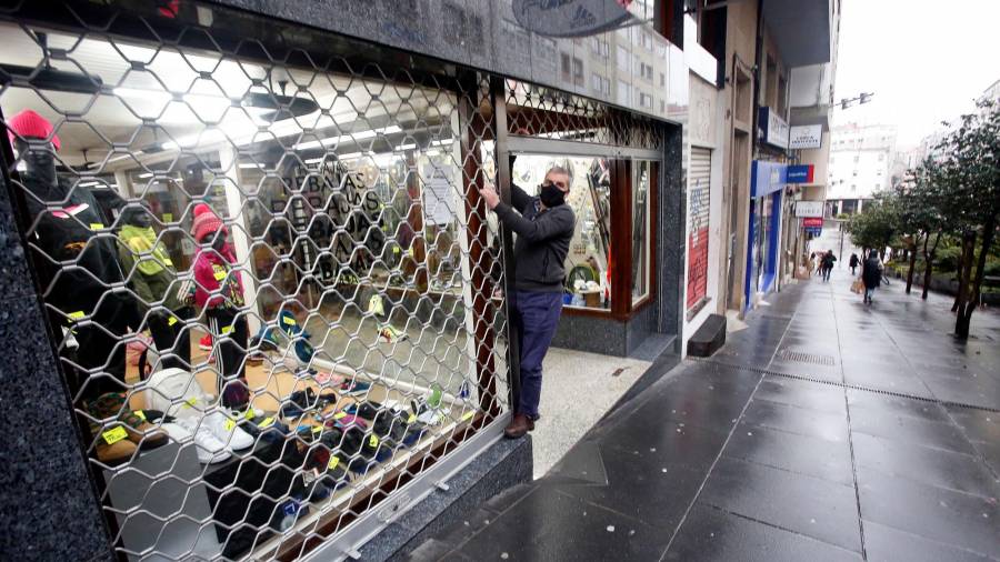 La tienda Deportes Cibeira bajando la persiana ayer a las seis de la tarde por las nuevas restricciones. Foto: Antonio Hernándezc