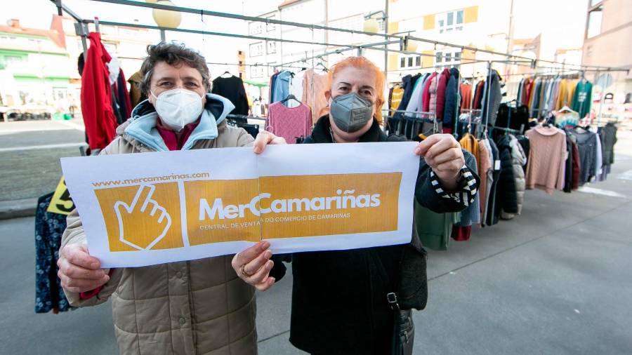 Dúas comerciantes con cartel promocional da plataforma MerCamariñas. Foto: Concello de Camariñas