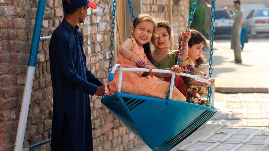 Niños montando un columpio en la celebración del fin del Ramadán en Pakistán. Efe
