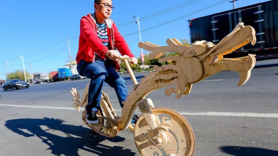 Un chino fabrica una bicicleta con forma de dragón hecha de palitos de helado