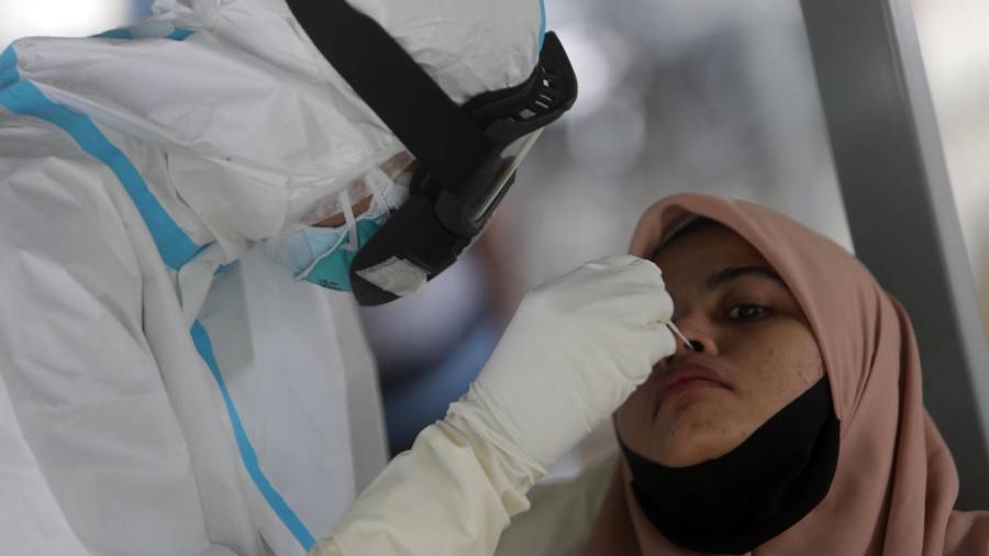 Banda Aceh (Indonesia), 12/10/2020.- Un sanitario toma muestras a una mujer en Banda Aceh (Indonesia) para la realización de un test de covid. HOTLI SIMANJUNTAK / EFE
