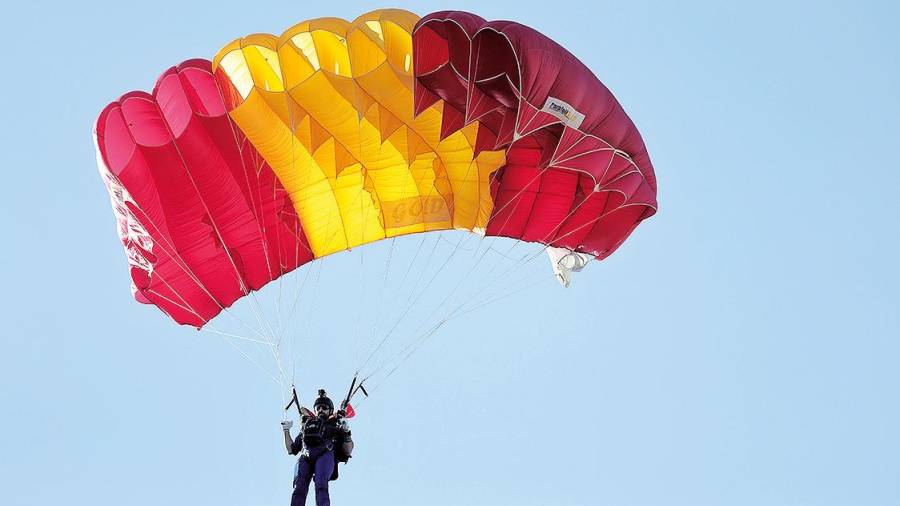 por aire. Un paracaidista sobrevolando el cielo de Madrid con los colores de la bandera nacional.